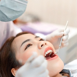 Woman preventing dental emergencies in Wayland by visiting her dentist