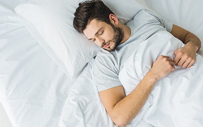Overhead view of bearded man sleeping in bed
