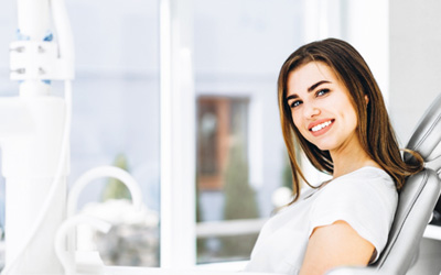 Female dental patient sitting and smiling after cosmetic dentistry in Wayland, MA