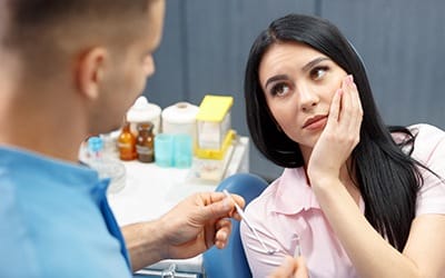 Young woman with dental pain seeing a dentist in Wayland.