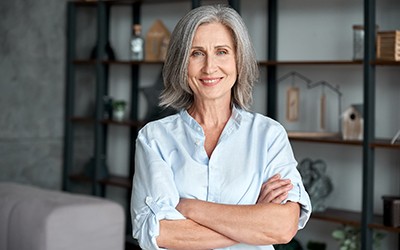 Older woman smiling with arms folded
