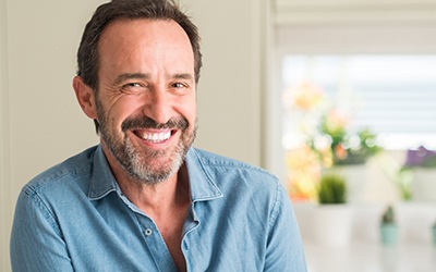 Man in blue shirt smiling at home