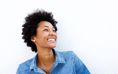 Woman in denim jacket looking up and smiling