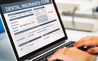 Filling out a dental insurance form on a laptop