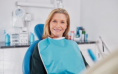 Senior woman sitting in dental chair and smiling