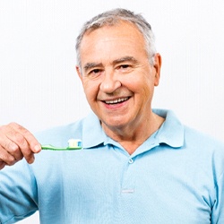 Man holding a toothbrush and smiling