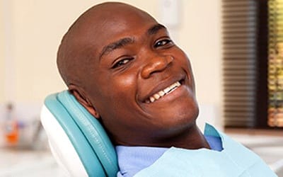 A man smiling in a dental chair.