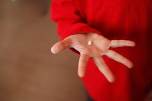 child red shirt holding tooth