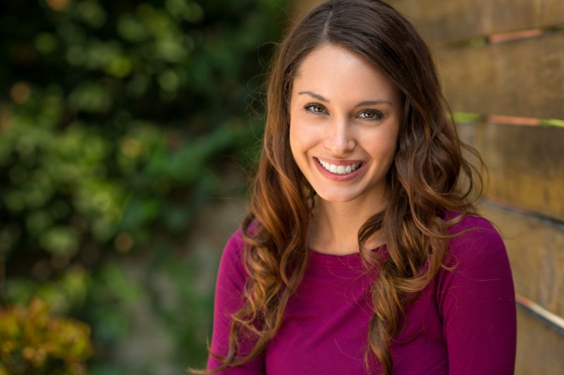 A woman smiling outside.