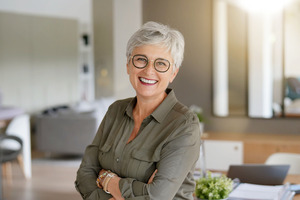 Close-up of smiling senior woman in grey shirt